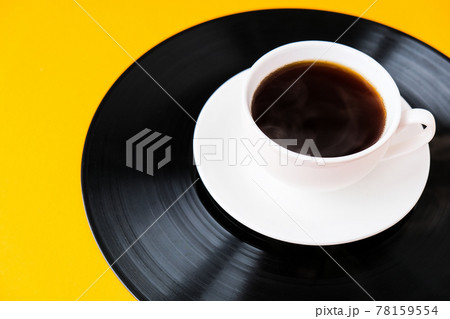 Cup of black coffee on vynil record. Copy space. Listening to music. Retro style 78159554