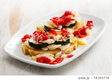 corn bread with cod fish and courgette on white dish 78160776