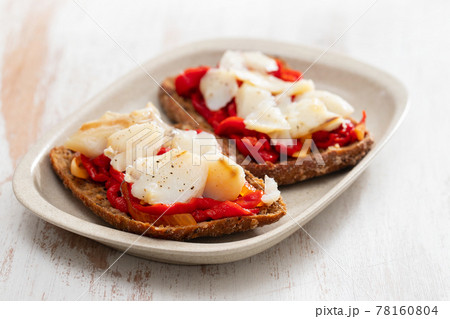 black healthy bread with cod fish and red pepper on dish 78160804