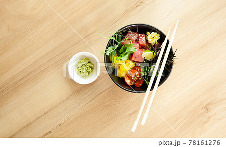 Poke salad with tuna in a bowl. Ingredients fresh tuna, cherry tomatoes, marinated seaweed, rice Poke salad with tuna in a bowl. Ingredients fresh tuna, cherry tomatoes, marinated seaweed, rice 78161276