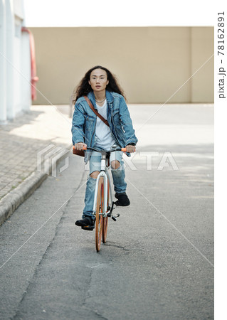 Young man with long hair riding bike in city - Stock Photo [78162891] -  PIXTA