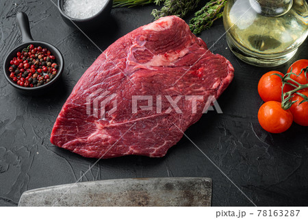 Beef meat cut raw with old butcher cleaver knife, on black background Beef meat cut raw with old butcher cleaver knife, on black background 78163287