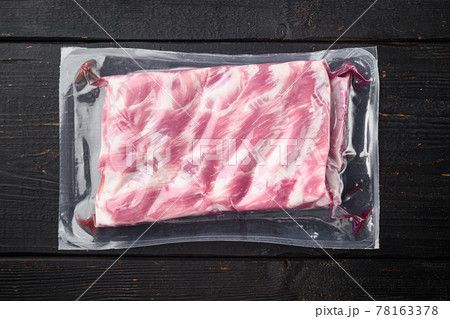 Pork ribs in a vacuum bag, on black wooden table background, top view flat lay Pork ribs in a vacuum bag, on black wooden table background, top view flat lay 78163378