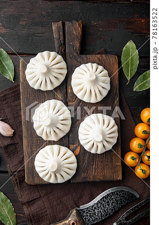 Khinkali Dumplings with beef and lamb meat, on old dark wooden table background, top view flat lay Khinkali Dumplings with beef and lamb meat, on old dark wooden table background, top view flat lay 78163522