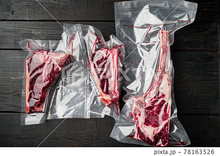 Dry aged vacuum steak , tomahawk, t bone and club steak cuts, on black wooden table background, top view flat lay 78163526