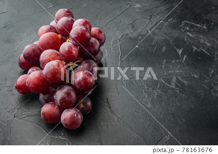Shine Grape fruit, dark red fruits, on black stone background, with copy space for text 78163676