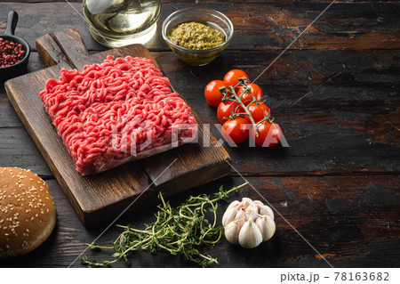 Raw minced meat with pepper, herbs and spices for cooking Meatball burger, on wooden cutting board, on old dark wooden table background, with copy space for text Raw minced meat with pepper, herbs and spices for cooking Meatball burger, on wooden cutting board, on old dark wooden table background, with copy space for text 78163682