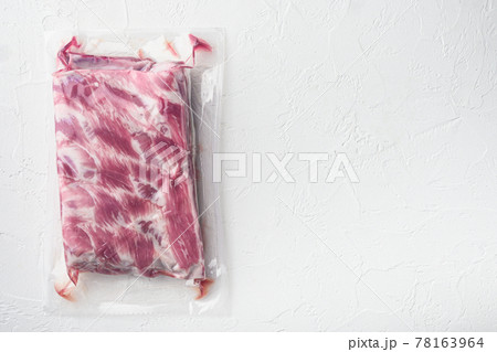 Vacuum packaging with raw pork rib, on white stone background, top view flat lay, with copy space for text Vacuum packaging with raw pork rib, on white stone background, top view flat lay, with copy space for text 78163964