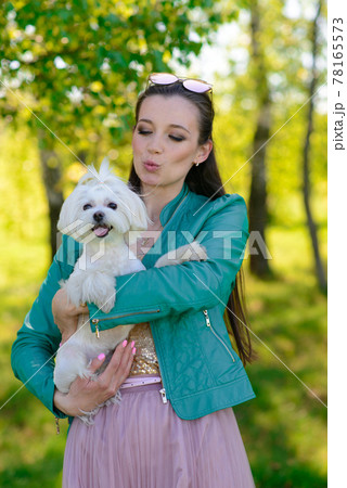 Young girl with her dog. Puppy white dog is running with it's owner. Concept about friendship, animal and freedom. 78165573