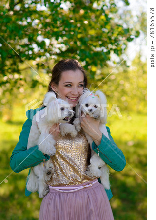 Young girl with her dog. Puppy white dog is running with it's owner. Concept about friendship, animal and freedom. Young girl with her dog. Puppy white dog is running with it's owner. Concept about friendship, animal and freedom. 78165578