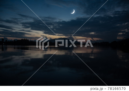 See the Islamic moon in the night sky. The evening sky and the vast river in darkness are beautiful. The crescent moon concept, the symbol of Islam, begins the month of Ramadan, eid al fitr 78166570