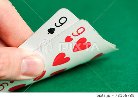 Hand holds a combination in poker - pair on a green background. Hand holds a combination in poker - pair on a green background. 78166739