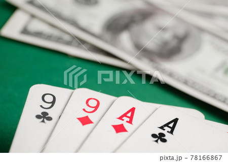 Two pair of aces and nines during poker with dollars on green table. 78166867