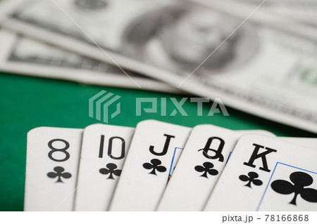 Flush of clubs cards during poker with dollar bills on green table. Flush of clubs cards during poker with dollar bills on green table. 78166868