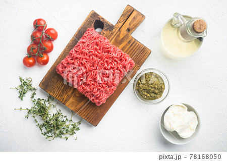 Fresh raw minced meat for meatballs with spices pepper, salt, mozzarella, pesto, on white stone background, top view flat lay Fresh raw minced meat for meatballs with spices pepper, salt, mozzarella, pesto, on white stone background, top view flat lay 78168050