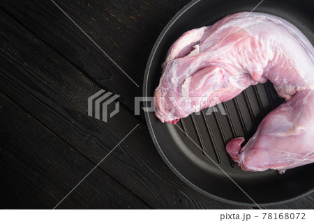 Whole Forest wild rabbit, in frying cast iron pan, on black wooden table , top view flat lay, with copy space for text 78168072