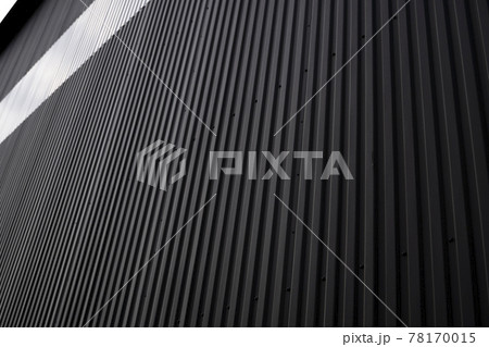 Black and white corrugated iron sheet used as a facade of a warehouse or factory. Texture of a seamless corrugated zinc sheet metal aluminum facade. Architecture. Metal texture. 78170015