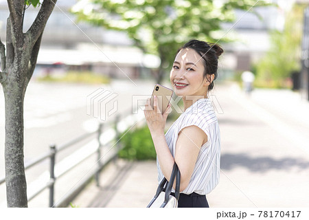 屋外でスマホを持つ女性 屋外でスマホを持つ女性 78170417