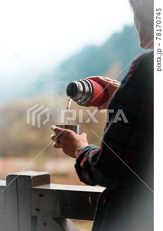 the girl pours tea from a thermos 78170745