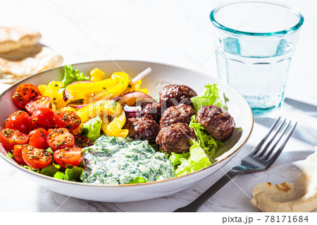 Greek food concept. Meatballs, tzatziki sauce, tomato and cucumber salad. Greek food concept. Meatballs, tzatziki sauce, tomato and cucumber salad. 78171684