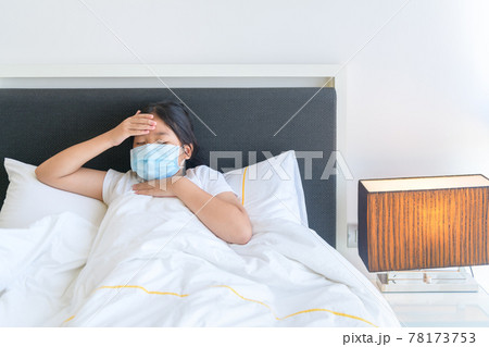 Sick girl wear mask and lying on bed Sick girl wear mask and lying on bed 78173753