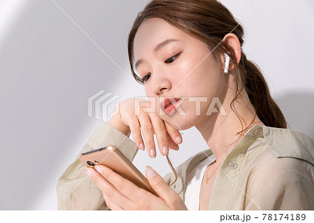 スマホでお気に入りの音楽を聴く若い女性 スマホでお気に入りの音楽を聴く若い女性 78174189
