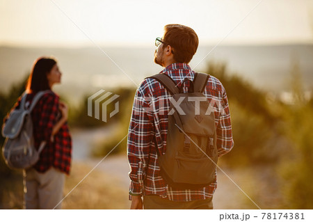 Portrait of happy young couple having fun on their hiking trip. Caucasian and asian hiker couple enjoying themselves on summer vacation. 78174381