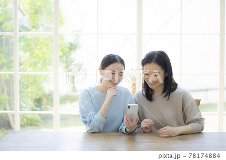 スマホを見て会話する女性 スマホを見て会話する女性 78174884