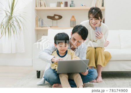 リビングでくつろぐ若い3人家族 78174900