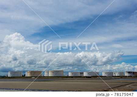 Oil tanks in a row under blue sky, Large white industrial tank for petrol, oil refinery plant. Energy and power Oil tanks in a row under blue sky, Large white industrial tank for petrol, oil refinery plant. Energy and power 78175047