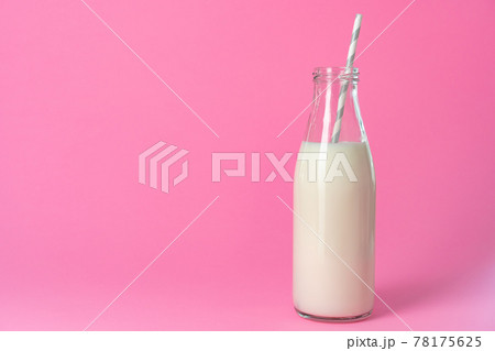 Glass bottle of milk against pink background Glass bottle of milk against pink background 78175625