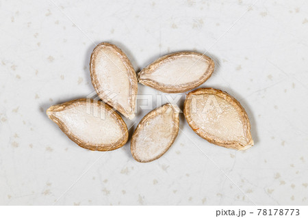 several whole pumpkin seeds close up on gray several whole pumpkin seeds close up on gray 78178773