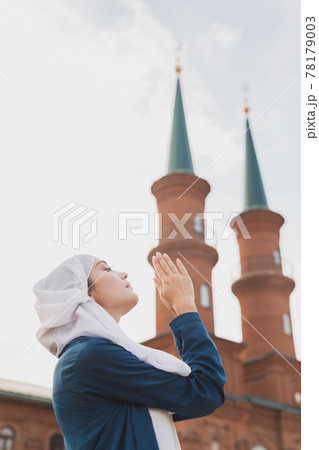 Muslim woman prayer wear hijab fasting pray to allah on mosque background 78179003
