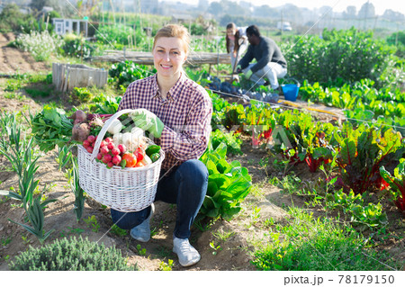 woman farmer holding wicker basket 78179150