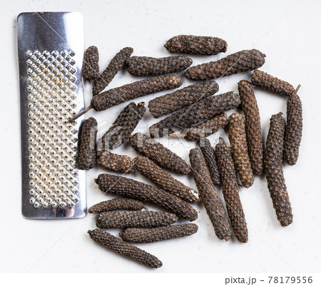 java long pepper with grater close up on gray 78179556