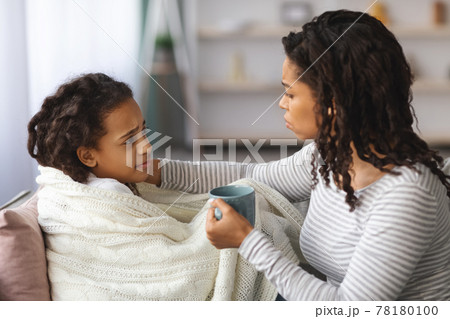 Black mother taking care of her sick daughter 78180100