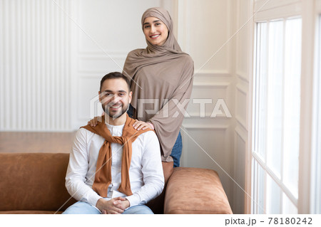Married Middle-Eastern Couple Posing Together Smiling To Camera At Home 78180242