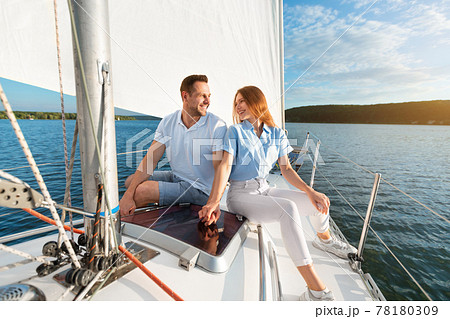 Couple Holding Hands Sitting On Sailboat Deck Enjoying Sailing Tour 78180309