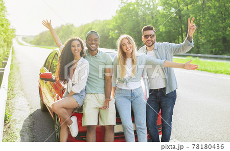 Portrait of cheerful multiethnic friends posing near their car on roadside, smiling at camera, panorama Portrait of cheerful multiethnic friends posing near their car on roadside, smiling at camera, panorama 78180436
