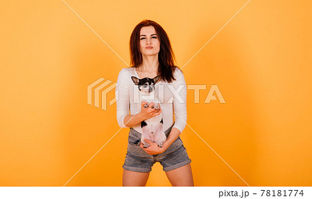 Young woman cuddling chihuahua puppy in studio Young woman cuddling chihuahua puppy in studio 78181774