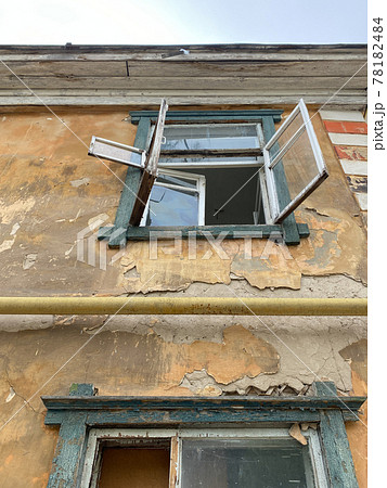 Broken window of an old house. The house is ready for demolition. Second floor, photo from below 78182484