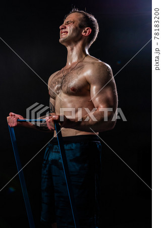 Man on black background keeps dumbbells pumped up in fitness sport, body strong hand, shirtless lifestyle. skin people fit With a ribbon in hand, the fitness gum is black Man on black background keeps dumbbells pumped up in fitness sport, body strong hand, shirtless lifestyle. skin people fit With a ribbon in hand, the fitness gum is black 78183200