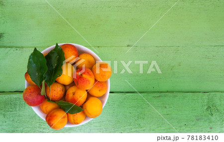 bowl with apricots on a wooden background bowl with apricots on a wooden background 78183410