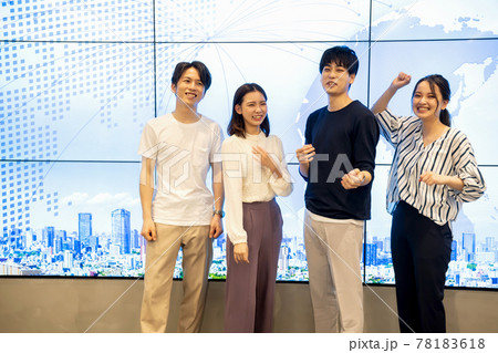 巨大モニターの前でポーズをとる若い男女 巨大モニターの前でポーズをとる若い男女 78183618