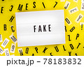 Lightbox text FAKE on yellow background with letters scattered, manipulation 78183832