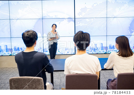 大型ビジョンの前でスピーチをする若い女性 大型ビジョンの前でスピーチをする若い女性 78184433