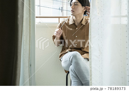 ベランダでうちわを持つ男性 78189373