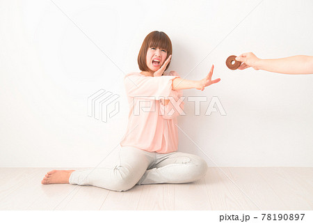 おやつを奪われ困惑する若い女性 78190897