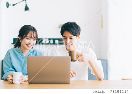 一緒にパソコンを見る若い夫婦 カップル 78191114