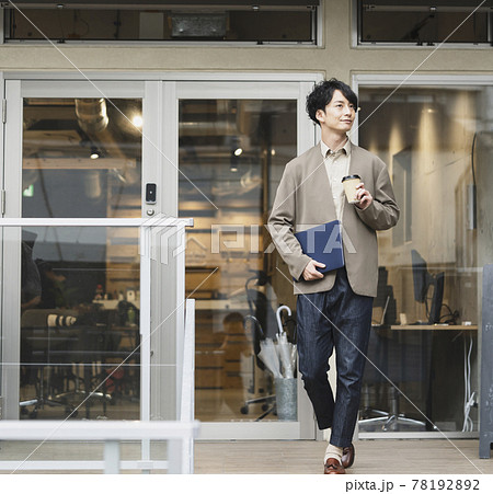 ノートパソコンとテイクアウトカップを持った若い男性　カジュアルビジネス イメージ 78192892